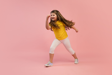 Image showing Happy caucasian little girl isolated on studio background. Looks happy, cheerful, sincere. Copyspace. Childhood, education, emotions concept