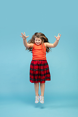 Image showing Happy caucasian little girl isolated on studio background. Looks happy, cheerful, sincere. Copyspace. Childhood, education, emotions concept