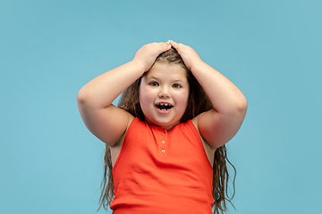 Image showing Happy caucasian little girl isolated on studio background. Looks happy, cheerful, sincere. Copyspace. Childhood, education, emotions concept