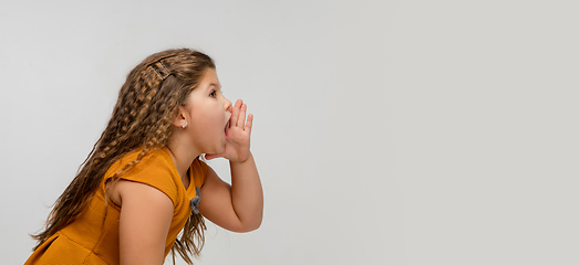 Image showing Happy caucasian little girl isolated on studio background. Looks happy, cheerful, sincere. Copyspace. Childhood, education, emotions concept