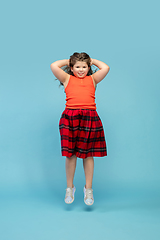 Image showing Happy caucasian little girl isolated on studio background. Looks happy, cheerful, sincere. Copyspace. Childhood, education, emotions concept