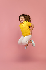 Image showing Happy caucasian little girl isolated on studio background. Looks happy, cheerful, sincere. Copyspace. Childhood, education, emotions concept