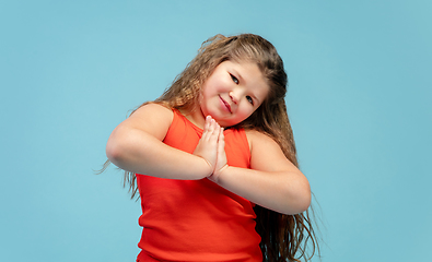 Image showing Happy caucasian little girl isolated on studio background. Looks happy, cheerful, sincere. Copyspace. Childhood, education, emotions concept