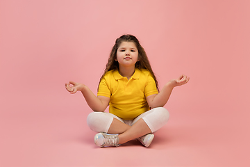 Image showing Happy caucasian little girl isolated on studio background. Looks happy, cheerful, sincere. Copyspace. Childhood, education, emotions concept