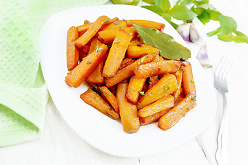 Image showing Carrots fried in plate on wooden board