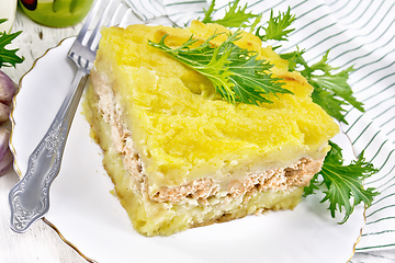 Image showing Casserole with potatoes and fish in plate on light wooden board