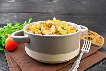 Image showing Chicken with vegetables and peas in saucepan on wooden board