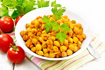 Image showing Chickpeas stewed with vegetables in plate on board