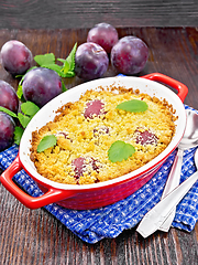 Image showing Crumble with plum in brazier on wooden board