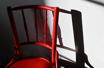 Image showing red ancient chair and its shadow on the wall