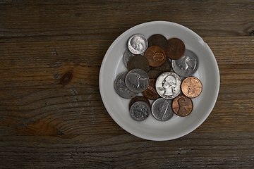 Image showing small American coins on a white porcelain saucer 