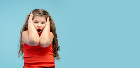 Image showing Happy caucasian little girl isolated on studio background. Looks happy, cheerful, sincere. Copyspace. Childhood, education, emotions concept