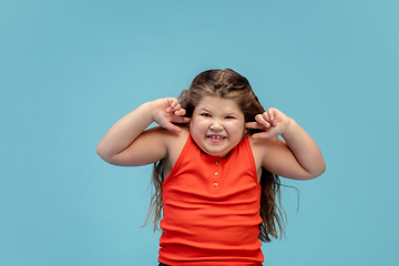 Image showing Happy caucasian little girl isolated on studio background. Looks happy, cheerful, sincere. Copyspace. Childhood, education, emotions concept