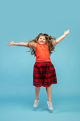 Image showing Happy caucasian little girl isolated on studio background. Looks happy, cheerful, sincere. Copyspace. Childhood, education, emotions concept