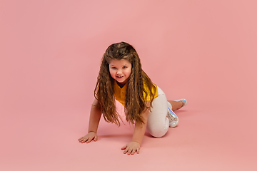 Image showing Happy caucasian little girl isolated on studio background. Looks happy, cheerful, sincere. Copyspace. Childhood, education, emotions concept