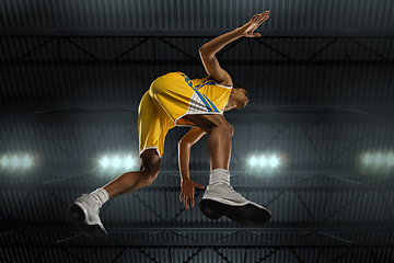 Image showing Young professional basketball player in action, motion isolated on black background, look from the bottom. Concept of sport, movement, energy and dynamic.