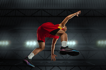 Image showing Young professional basketball player in action, motion isolated on black background, look from the bottom. Concept of sport, movement, energy and dynamic.