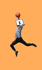 Image showing Young man headed of TV set jumping as basketball player on orange background.