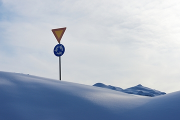 Image showing roundabout signs and give way in winter among snowdrifts in Finl