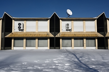 Image showing abandoned non residential building  with satellite dish on the r