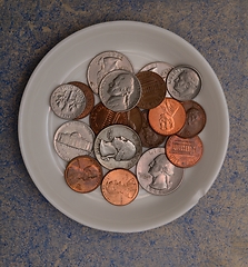 Image showing small american coins on a white saucer