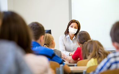 Image showing teacher in mask with group of children at school