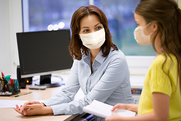 Image showing teacher and student girl in masks at school