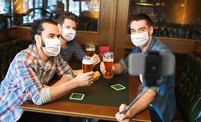 Image showing men in masks take selfie and drink beer at bar