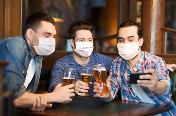 Image showing men in masks take selfie and drink beer at bar