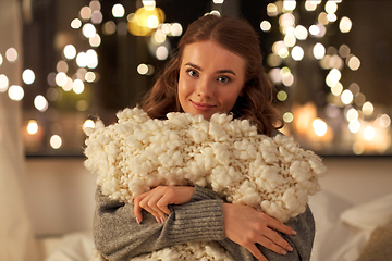 Image showing happy young woman with soft pillow in bed at home