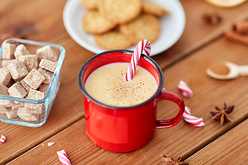 Image showing cup of eggnog with candy cane, cookies and sugar