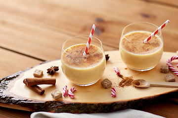 Image showing glasses of eggnog, ingredients and spices on wood