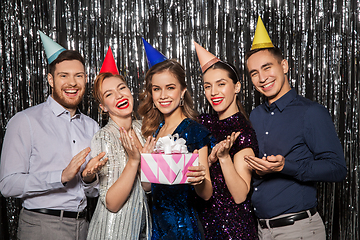 Image showing happy friends in party hats with birthday gift