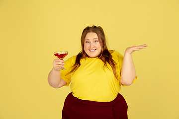 Image showing Beautiful caucasian plus size model isolated on yellow studio background. Concept of inclusion, human emotions, facial expression