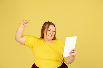 Image showing Beautiful caucasian plus size model isolated on yellow studio background. Concept of inclusion, human emotions, facial expression