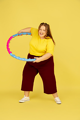 Image showing Beautiful caucasian plus size model isolated on yellow studio background. Concept of inclusion, human emotions, facial expression