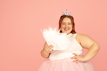 Image showing Beautiful caucasian plus size model isolated on pink studio background. Concept of inclusion, human emotions, facial expression