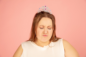 Image showing Beautiful caucasian plus size model isolated on pink studio background. Concept of inclusion, human emotions, facial expression