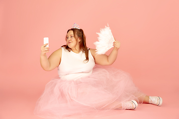 Image showing Beautiful caucasian plus size model isolated on pink studio background. Concept of inclusion, human emotions, facial expression