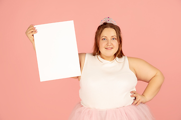 Image showing Beautiful caucasian plus size model isolated on pink studio background. Concept of inclusion, human emotions, facial expression