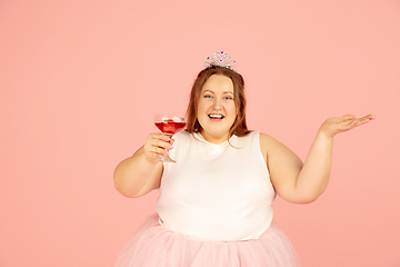 Image showing Beautiful caucasian plus size model isolated on pink studio background. Concept of inclusion, human emotions, facial expression