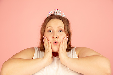 Image showing Beautiful caucasian plus size model isolated on pink studio background. Concept of inclusion, human emotions, facial expression