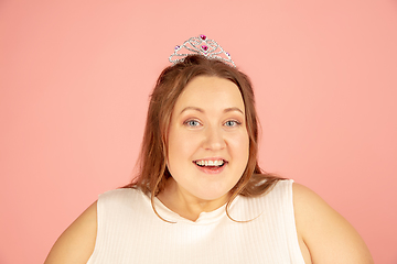 Image showing Beautiful caucasian plus size model isolated on pink studio background. Concept of inclusion, human emotions, facial expression