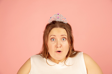 Image showing Beautiful caucasian plus size model isolated on pink studio background. Concept of inclusion, human emotions, facial expression