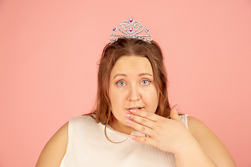 Image showing Beautiful caucasian plus size model isolated on pink studio background. Concept of inclusion, human emotions, facial expression