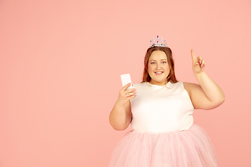 Image showing Beautiful caucasian plus size model isolated on pink studio background. Concept of inclusion, human emotions, facial expression