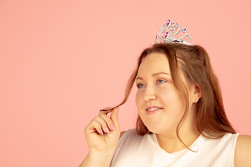 Image showing Beautiful caucasian plus size model isolated on pink studio background. Concept of inclusion, human emotions, facial expression