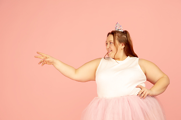 Image showing Beautiful caucasian plus size model isolated on pink studio background. Concept of inclusion, human emotions, facial expression