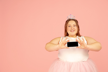 Image showing Beautiful caucasian plus size model isolated on pink studio background. Concept of inclusion, human emotions, facial expression