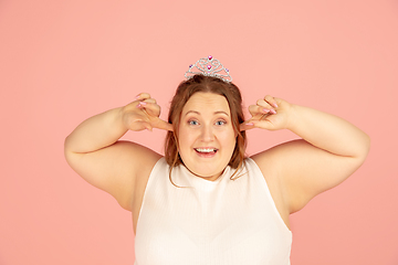 Image showing Beautiful caucasian plus size model isolated on pink studio background. Concept of inclusion, human emotions, facial expression